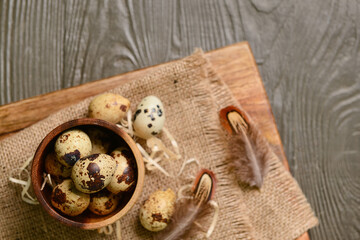 Bowl with fresh quail eggs on brown wooden background