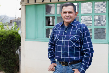 Portrait of Hispanic man in the patio of his house - Latino man in his 50s smiling