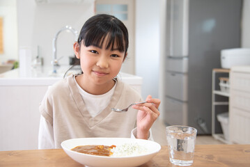 1人でカレーライスを食べるアジア人の子供