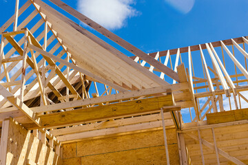 View of roof truss system beams wooden frame house under construction