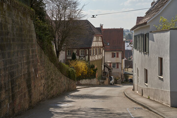 sloping street with traditional houses and a blooming forsythia bush in Steinheim an der Murr, Germany