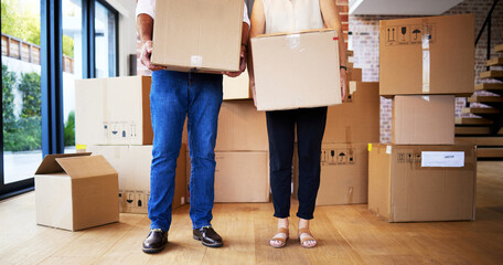 Boxes full of possessions, hearts full of priceless memories. Shot of an unrecognisable mature couple carrying boxes on moving day.