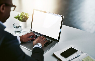 Focused on beating the deadline. High angle shot of an unrecognizable young businessman working on his laptop in a modern office.