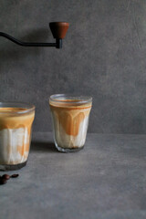 Dirty latte coffee mixed with cold fresh milk in the morning on dark background. Coffee shop cafe.