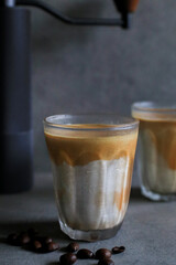 Dirty latte coffee mixed with cold fresh milk in the morning on dark background. Coffee shop cafe.