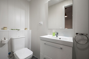 Fototapeta na wymiar Bathroom with white porcelain sink on white wood cabinet, square frameless mirror and chrome accents