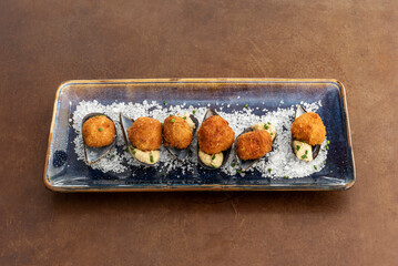Delicious croquettes stuffed with salted prawns and lots of coarse salt served as tapas in a Spanish restaurant