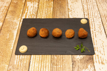 Tapa of Spanish croquettes stuffed with bechamel sauce and pieces of serrano ham with dipping sauce...