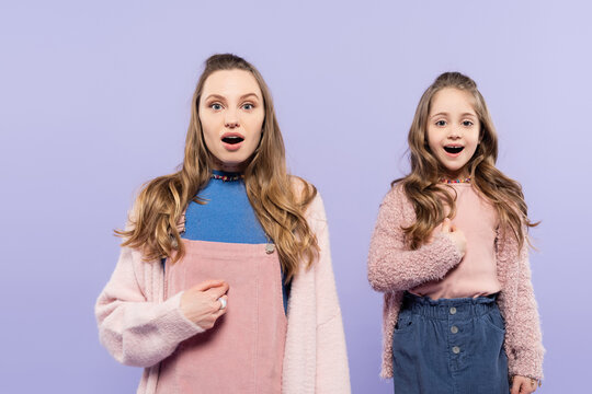 Amazed Mother And Daughter Pointing At Themselves Isolated On Purple.