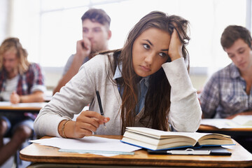 How will I handle this course load. An overworked young student sitting with her head in her hands.