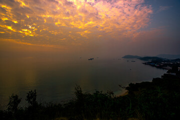 The background of the sea by the evening sea, with natural beauty (sea water, rocks, sky) and fishermen are fishing by the river bank, is a pleasure during travel.