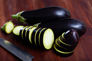 Chopped organic eggplants on wooden background. Vegetarian food concept