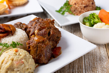 A closeup view of braised oxtail cuts, part of a plated entree.