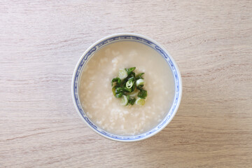 Rice porridge with spring onion on the table 