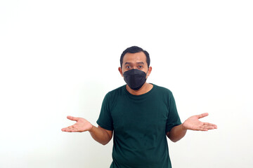 Naklejka premium Happy asian man wearing face mask standing while presenting with both hand. Isolated on white