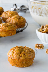 Carrot cake muffins with cream cheese icing in a bowl ready for decorating.