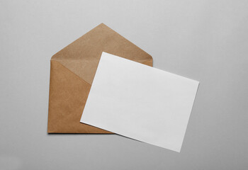 Brown envelope with blank letter on grey background, top view