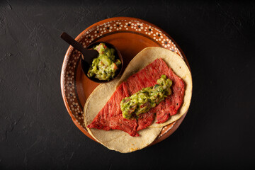 Tacos de Cecina Enchilada con Guacamole. Salted, sun-dried pork or beef meat, seasoned with various spices and chili peppers, usually eaten in tacos