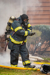 Firefighter wearing protective gear and oxygen mask
