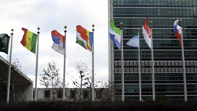 Flags in front of United Nations. Slow motion flags flying in wind. United Nations Building in New York City