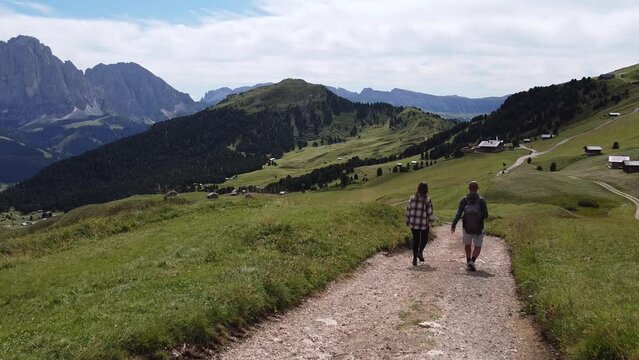 Couple Walking the Hike to Val Gardena Valley and Seceda Mountain Peak in South Tyrol, Italian Alps, Dolomites, Italy