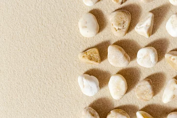 Fotobehang Zen Stenen Pebble sea stones on fine sand. Natural stone neutral beige yellow color, monochrome tones. Summer minimal design background with copy space  © yrabota