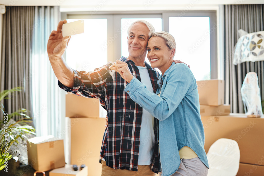 Poster you havent fully moved in without that first selfie. shot of a happy mature couple taking a selfie o