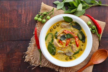Thai Green curry with chicken  - Thai authentic food called  Kiew Wan with some ingredients at copy space of wood table
