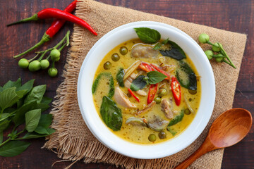 Thai Green curry with chicken - Thai authentic food called  Kang Kiew Wan with some ingredients at top view on wood table