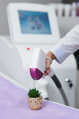 laser hair removal device. jokingly makes epilation on a green thorny flower. epilation machine in...