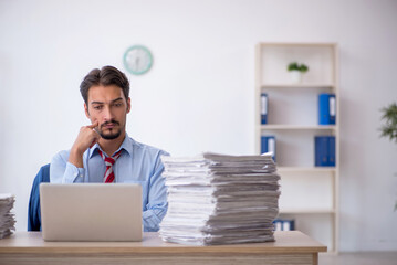 Young male employee and too much work in the office