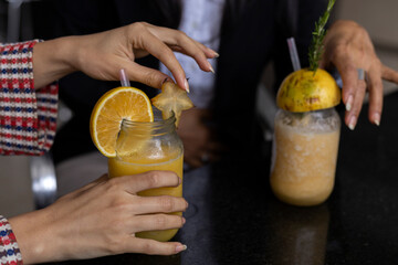 Hands of mom and her Latin American daughter share a fruit drink. unrecognizable. Mother's Day and healthy living concepts