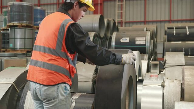 Industrial worker measuring detail and quality control of roll metal sheet roof with tape measure before shipment to customer at factory warehouse manufacture