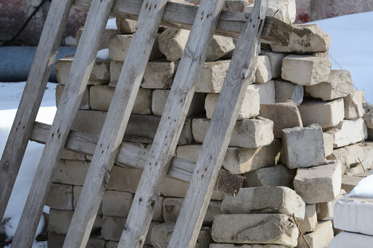 White brick stacked on a pallet in the snow. Construction production background.