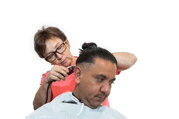 Focus on young Latin man getting his hair cut by older woman and professional stylist. Selective focus