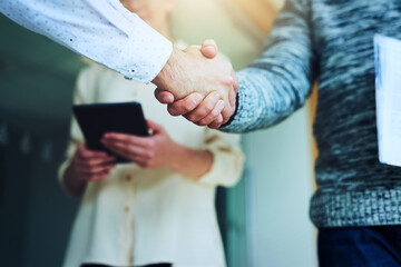 Obraz na płótnie Canvas Partnering together to take over the business world. Closeup shot of unrecognizable businesspeople shaking hands in an office.