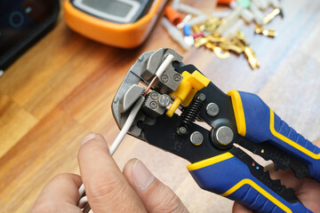 Wire strippers or cable strippers tool . Electrician holding cable strippers tool to remove insulation from electrical wires.Work Safely and Tools concept