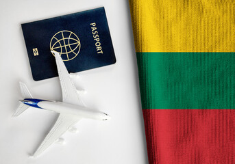 Flag of Lithuania with passport and toy airplane. Flight travel concept - obrazy, fototapety, plakaty