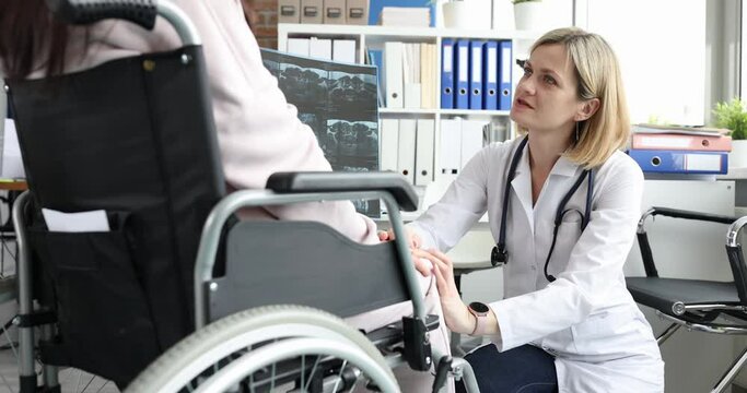 Woman doctor comforts a patient with x-ray in wheelchair
