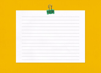 Empty note paper with clip on yellow art paper background.