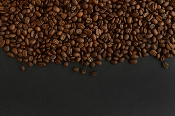 Coffee beans on a black background. Top view. Copy space