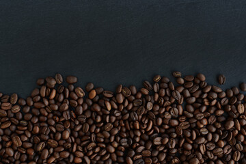 Roasted Coffee beans on a black background. Top view. Copy space