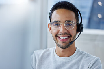 Fototapeta premium I hope I can be of service to you today. Shot of a young businessman working at his desk in his office.
