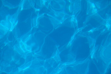 Fototapeta na wymiar Beautiful blue water background. Texture of water surface of pool is transparent, clean water with light refraction and reflection on water surface, with copy place. 