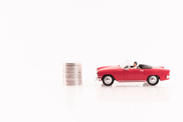 Véhicule miniature cabriolet rouge avec des pièces de monnaie.