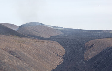 Fototapeta na wymiar Fagradalsfjall volcano spitting smoke, helicopter in the sky