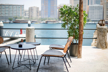 Fototapeta na wymiar An outdoor cafe overlooking the Dubai Creek water canal with the Deira district in the background