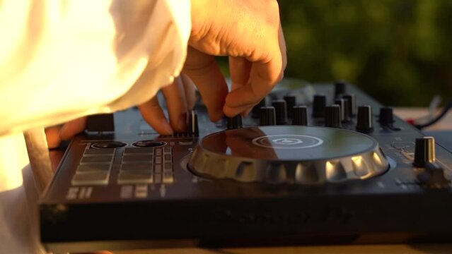 Close up of person outdoor DJing in the sunset.