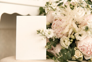 A luxurious wedding bouquet next to an empty invitation