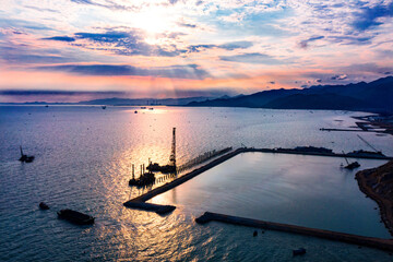 Fototapeta premium Seaport industry - Transportation and logistic . Industrial cranes and ships in the sunset.
